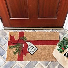 a door mat with a red ribbon and a bow on it