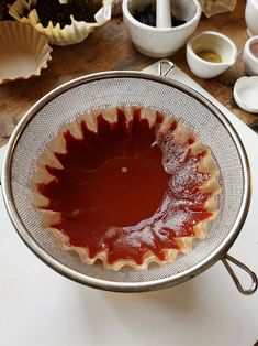 a bowl filled with sauce sitting on top of a table