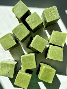 several squares of green colored food on a white surface