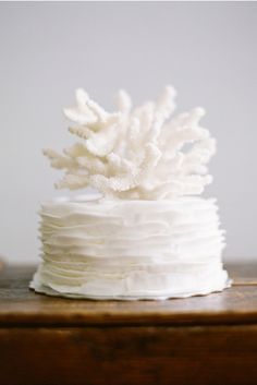 a white frosted cake sitting on top of a wooden table