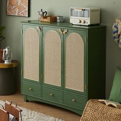 a green cabinet with wicker doors and handles in a living room next to a couch