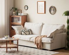 a living room with a white couch and coffee table in front of a large window