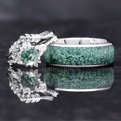 two wedding rings with green and white stones