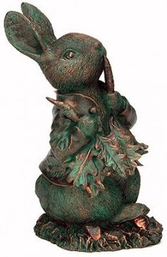 a statue of a rabbit holding an acorn