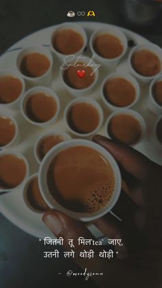 someone holding a cup of coffee in front of a plate with small cups on it