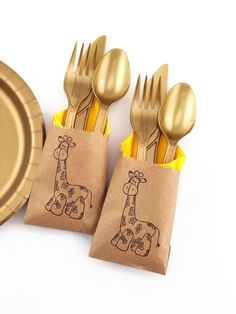 two giraffes are on brown paper bags with gold forks and spoons