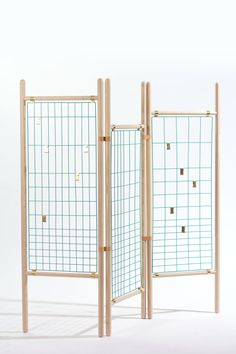 two wooden screens with squares and holes on them, one is open to show the other side