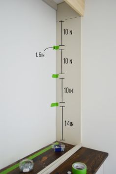 the height of a window is shown with measuring tape and cups on top of it