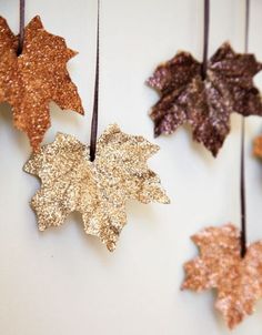 the words charming leaf art ideas are hanging from strings with gold and brown leaves on them