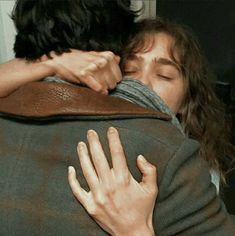 two people are hugging each other and one is wearing a jacket