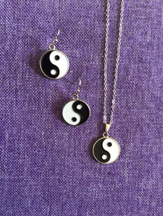 (18,086) Yin-Yang Necklace and Earrings  Stainless Steel Enamel, 5/8" in diameter  Earrings on rhodium ear wires Necklace on 16" stainless steel chain Yin Yang Necklace, Wire Necklace, Necklace And Earrings, Steel Chain, Yin Yang, Stainless Steel Chain, Ear Wires, Jewelry Sets, Beauty Book