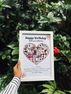 someone holding up a birthday card in front of some plants