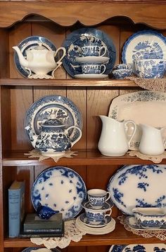 an old china cabinet with blue and white dishes