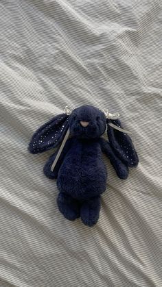 a blue stuffed animal laying on top of a bed