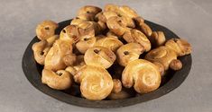 a bowl filled with lots of doughnuts on top of a table