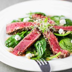 seared peppercorn tuna steak with spinach and feta cheese on top