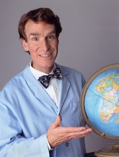 a man in a bow tie holding up a globe