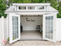 a small white shed with the door open