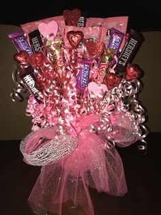 a candy bouquet with pink ribbon and hearts