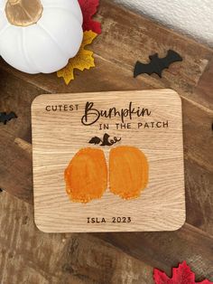 a wooden coaster with two pumpkins on it