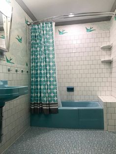 a bath room with a tub a sink and a shower head mounted to the wall