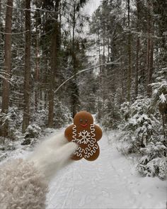 a gingerbread man on skis is in the middle of a snowy path with trees