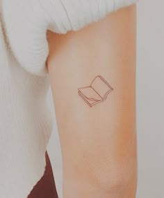 a woman's arm with a book tattoo on the left side of her arm