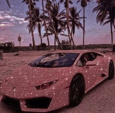 a pink sports car parked in front of palm trees with stars on the hood and wheels