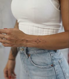 a woman's arm with small stars on it