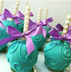 chocolate covered candies with purple ribbons and pearls on them are ready to be eaten