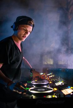 a man in headphones mixing music on a turntable