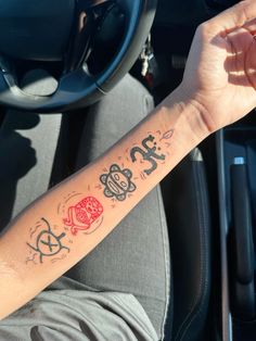 a person with a tattoo on their arm sitting in a car