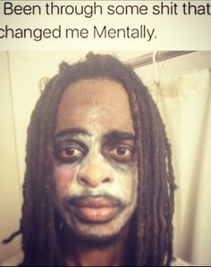 a man with dreadlocks and makeup on his face