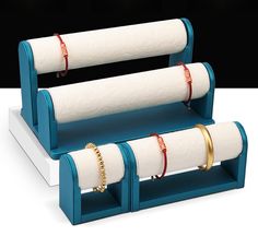 two white napkin holders with gold rings on them