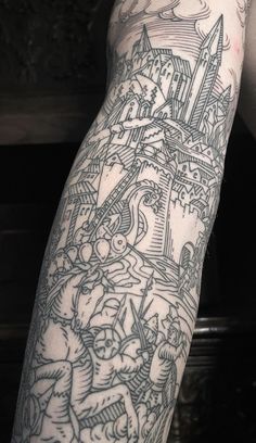 a man's arm with tattoos on it and an image of a castle in the background