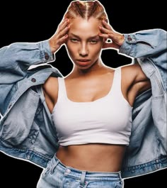 a woman in white shirt and jean jacket holding her hands to her head with both hands