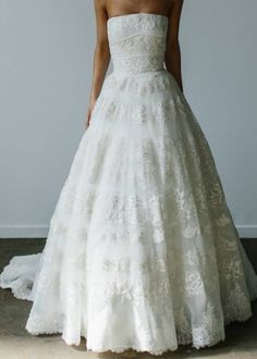 a woman in a white wedding dress standing on the floor