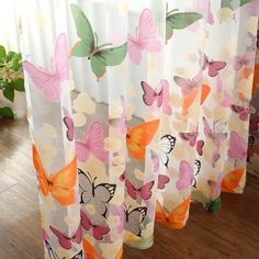 the curtains are lined up with butterflies on them