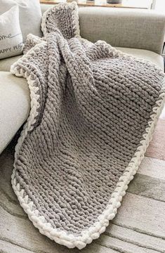 a gray blanket sitting on top of a couch