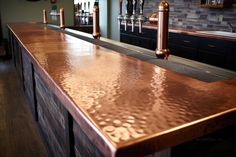 a bar with copper colored counter tops in a restaurant