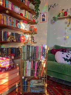 a living room filled with lots of books on top of a book shelf next to a green couch