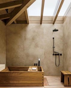 an image of a bathroom setting with wood accents and skylights above the bathtub