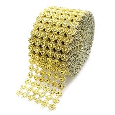 a roll of gold and silver sequins on a white background with some beads attached to it