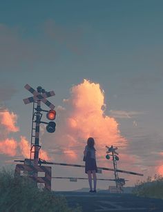 a woman standing on top of a road next to a traffic light under a cloudy sky