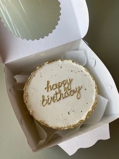 a birthday cake with the words happy birthday written on it in gold foil and white frosting