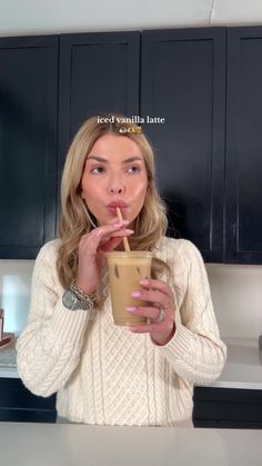 a woman drinking from a coffee cup with the caption iced vanilla latte on it