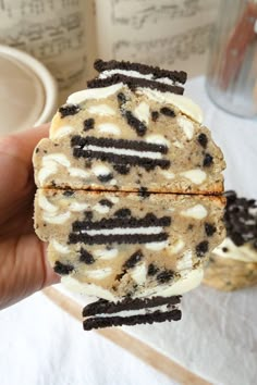 someone is holding an ice cream sandwich with oreo cookies on it in their hand