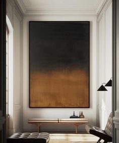 a large painting hanging on the wall above a bench in a room with white walls