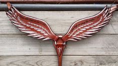 a brown leather wall hanging with wings on it