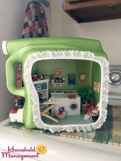 a green toy microwave oven sitting on top of a counter next to a washer and dryer